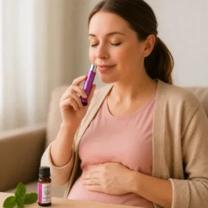 Olejki eteryczne w ciąży - kobieta w ciąży używa osobistego inhalatora aromaterapeutycznego z olejkami eterycznymi, obok buteleczka olejku lawendowego AromatherapyOils