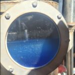 Olejek Australian Rosewood (Dysoxylum fraserianum) w trakcie procesu destylacji – szklane naczynie z niebieskawym olejkiem bogatym w seskwiterpeny.